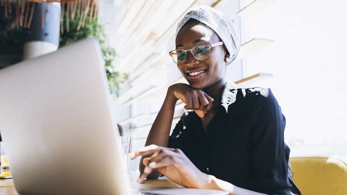 Woman smiling while typing on her laptop